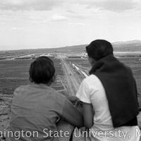 Young men looking down onto the barracks from a distance