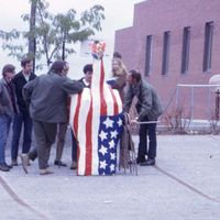 Sculpture of red, white, and blue hand with middle finger extended